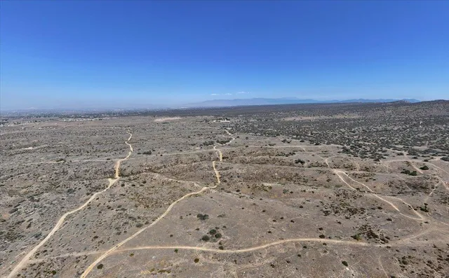 a view of a dry yard with mountains in the background