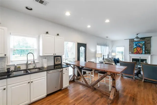 a kitchen with stainless steel appliances granite countertop a stove a sink dishwasher and a refrigerator with wooden floor