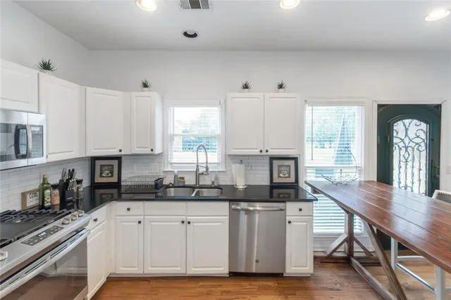 a kitchen with stainless steel appliances a refrigerator and a stove top oven