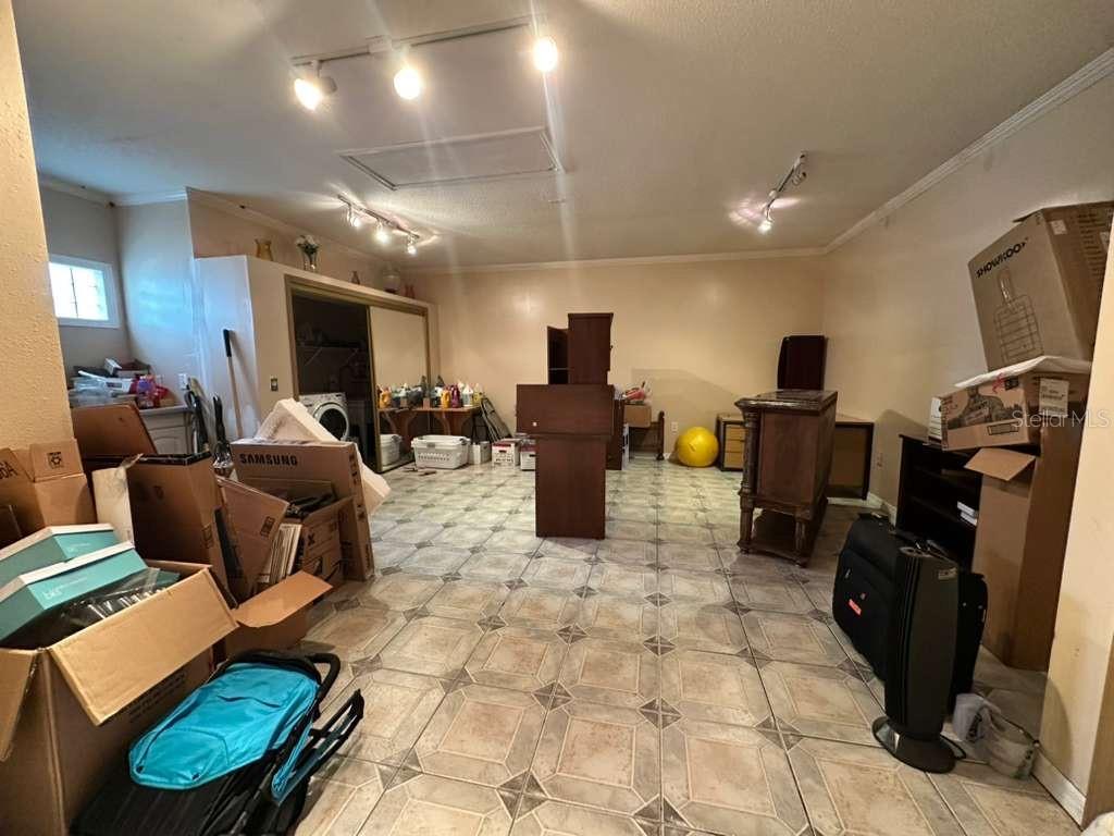 607 Gaul Way Kissimmee, FL 34759 - Photo 14 of 30 a living room with furniture a flat screen tv and a refrigerator
