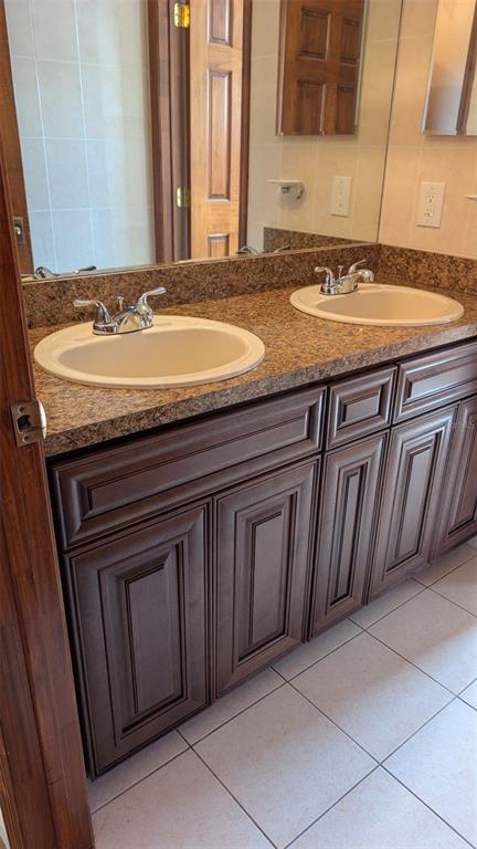 607 Gaul Way Kissimmee, FL 34759 - Photo 29 of 30 a bathroom with a granite countertop sink and a mirror