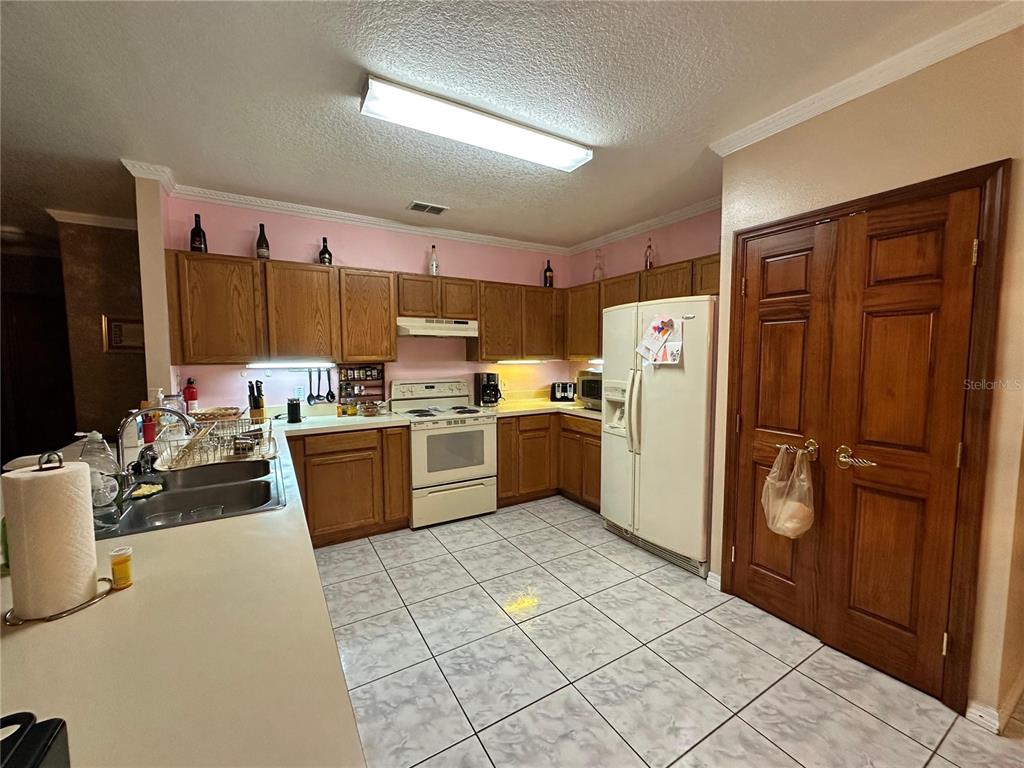 607 Gaul Way Kissimmee, FL 34759 - Photo 9 of 30 a kitchen with stainless steel appliances a refrigerator and a stove