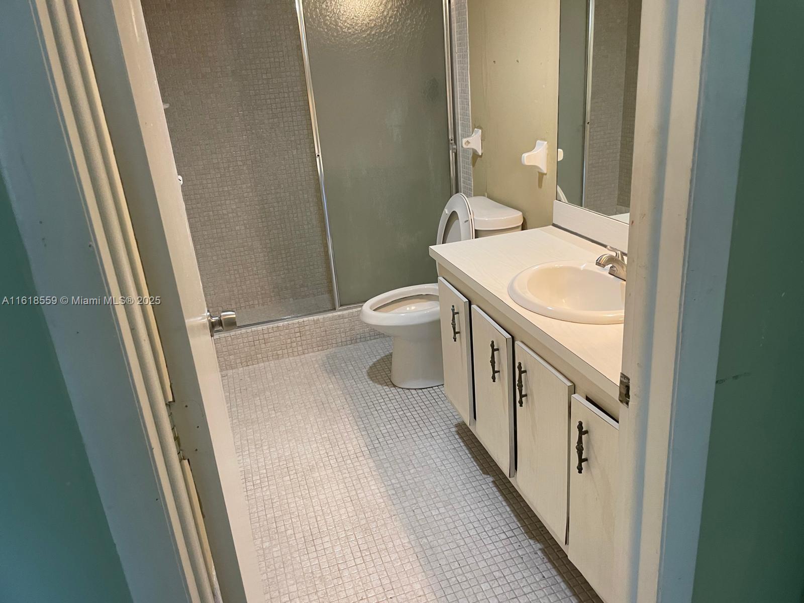 4168 Inverrary Drive, Unit 302 Lauderhill, FL 33319 - Photo 15 of 25 a bathroom with a sink a toilet a mirror and shower