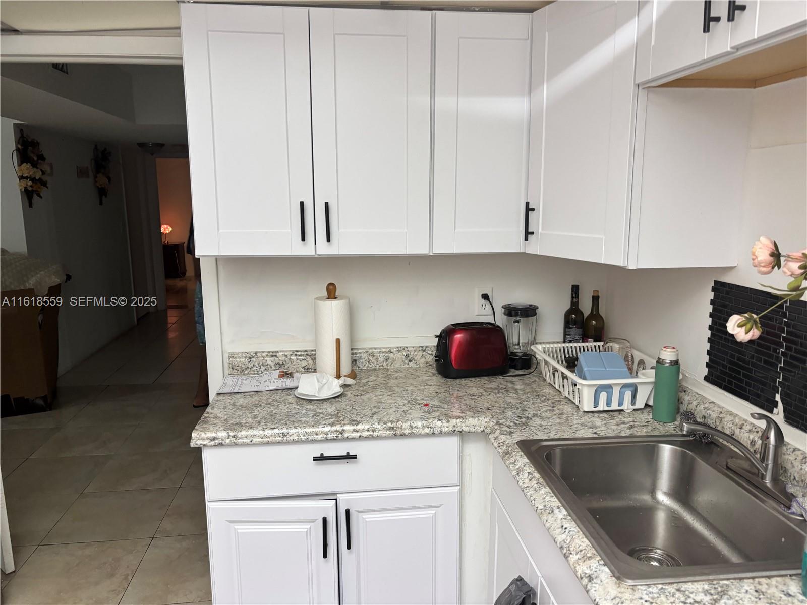 4168 Inverrary Drive, Unit 302 Lauderhill, FL 33319 - Photo 9 of 25 a kitchen with granite countertop a sink a stove and cabinets