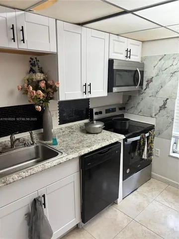 a kitchen with stainless steel appliances granite countertop a sink and a stove