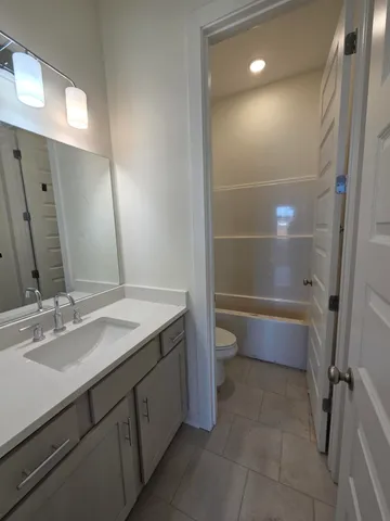 a bathroom with a sink a toilet and a mirror
