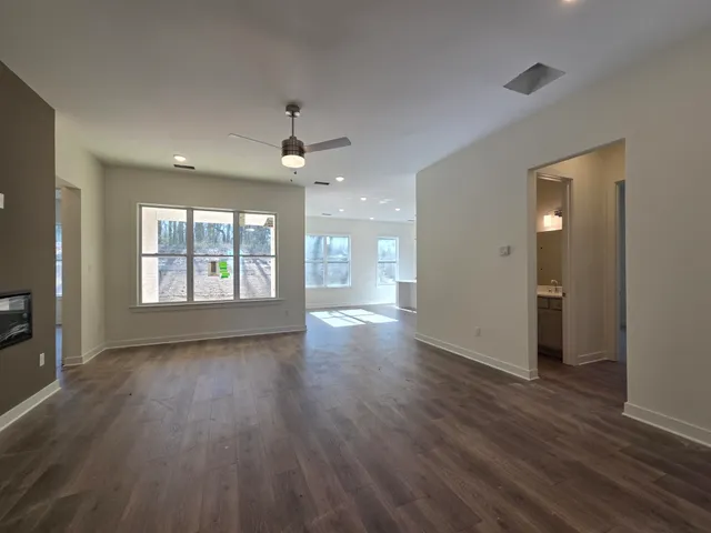 a view of an empty room with window and wooden floor