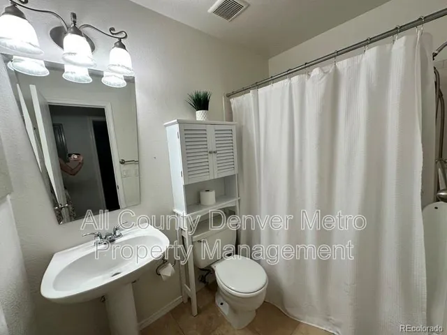 a bathroom with a double vanity sink mirror and toilet