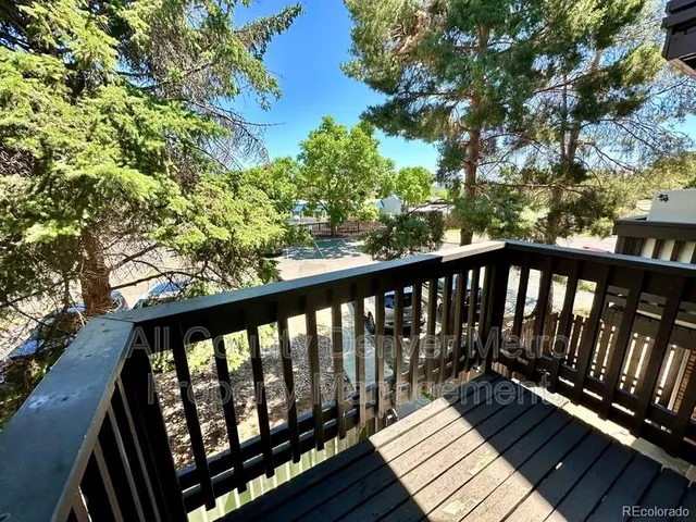 a balcony with wooden floor and fence