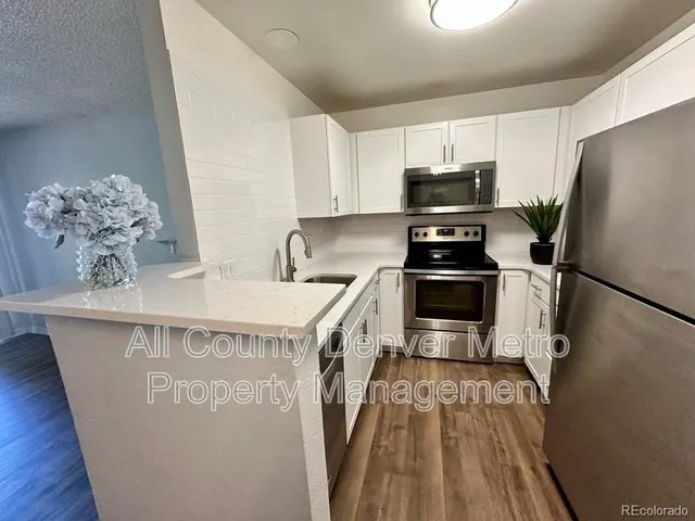 a kitchen with stainless steel appliances a refrigerator a sink a stove and cabinets