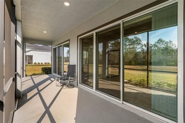 a view of a big house with a big yard and large trees
