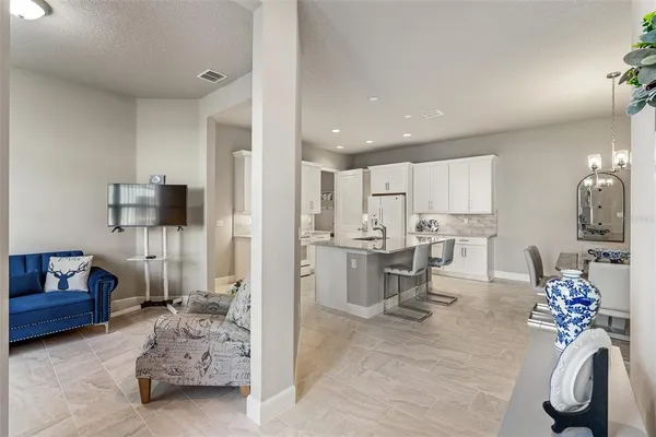 a kitchen with a sink a stove a refrigerator and white cabinets