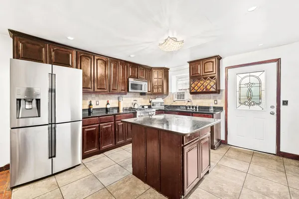 a kitchen with stainless steel appliances granite countertop a refrigerator stove sink and cabinets