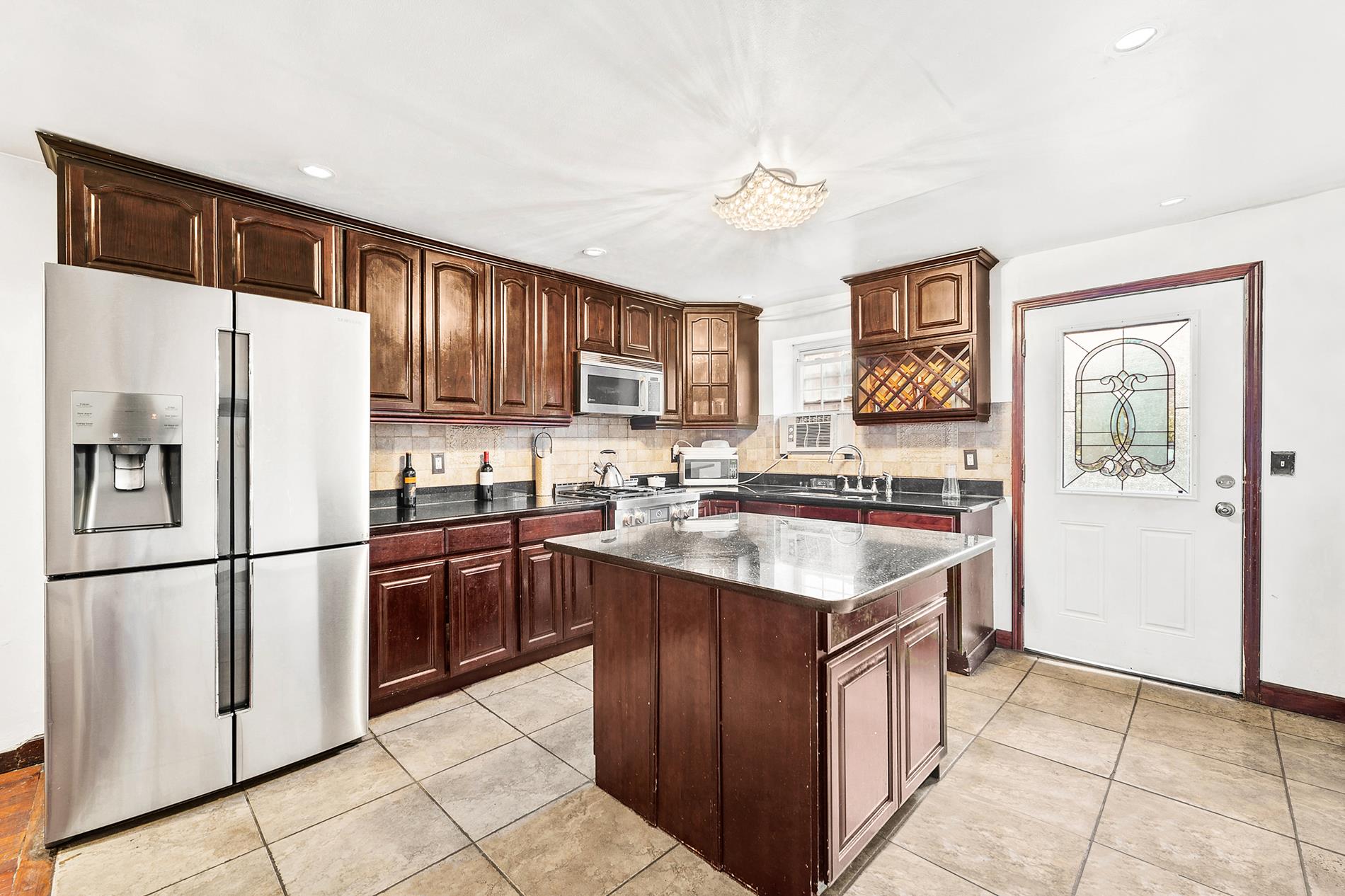a kitchen with stainless steel appliances granite countertop a refrigerator stove sink and cabinets