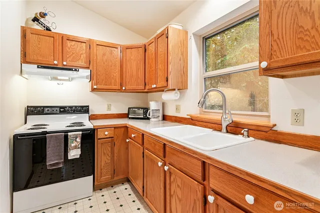a kitchen with stainless steel appliances a sink stove and a window