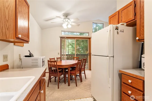 a dining room with stainless steel appliances a table and chairs