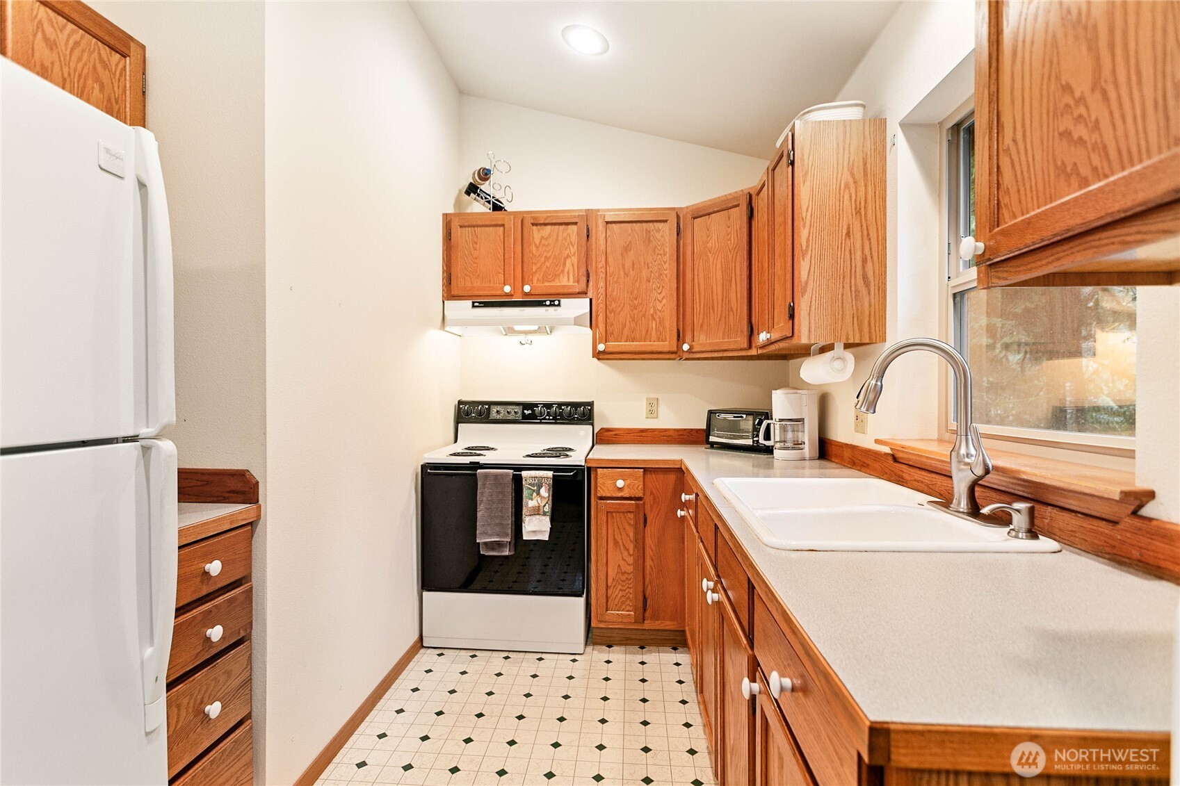 22014 Pinnacle Road Glacier, WA 98244 - Photo 10 of 31 a kitchen with stainless steel appliances a sink a stove a refrigerator cabinets and a window
