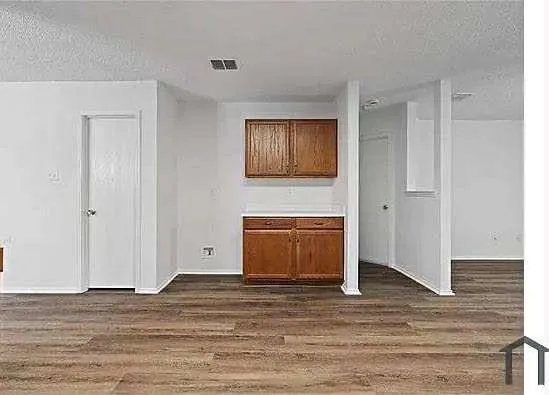 a view of empty room with wooden floor and cabinet