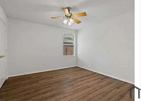 a view of a room with wooden floor and a ceiling fan