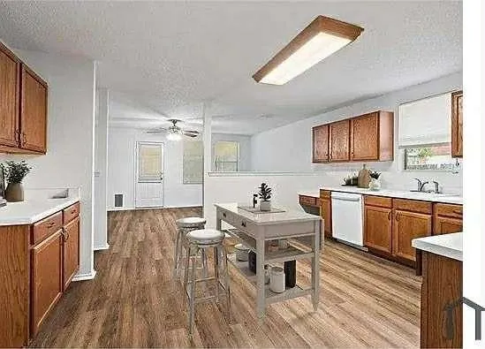 a kitchen with granite countertop a sink appliances cabinets and wooden floor