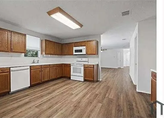 a kitchen with a white cabinets a sink and wooden floor