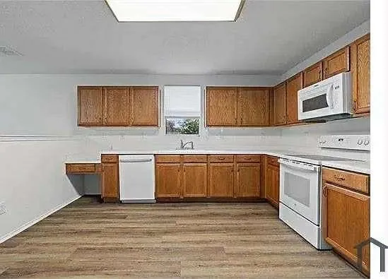 a kitchen with stainless steel appliances granite countertop a sink and wooden cabinets