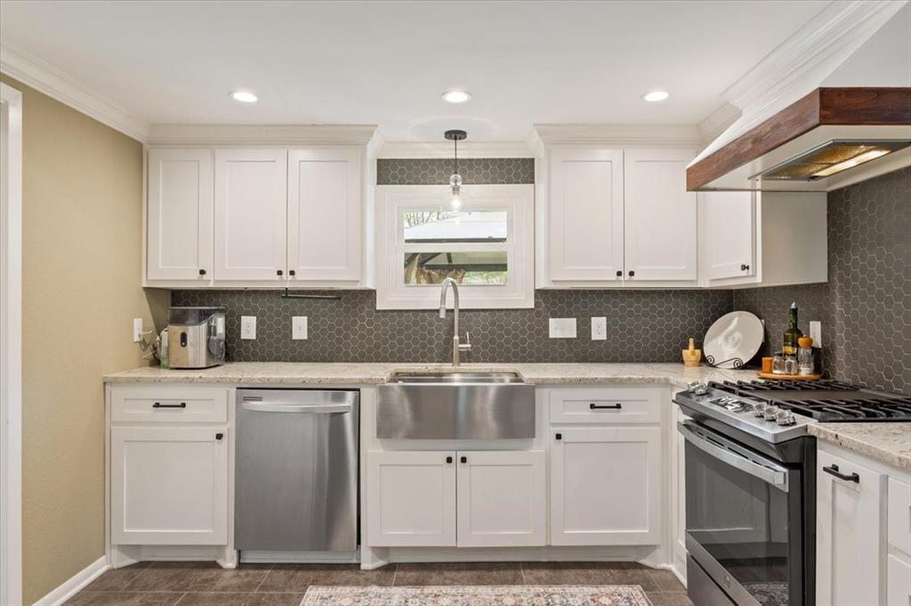 2209 North 52nd Street Waco, TX 76710 - Photo 14 of 34 a kitchen with stainless steel appliances granite countertop a stove a sink and a microwave