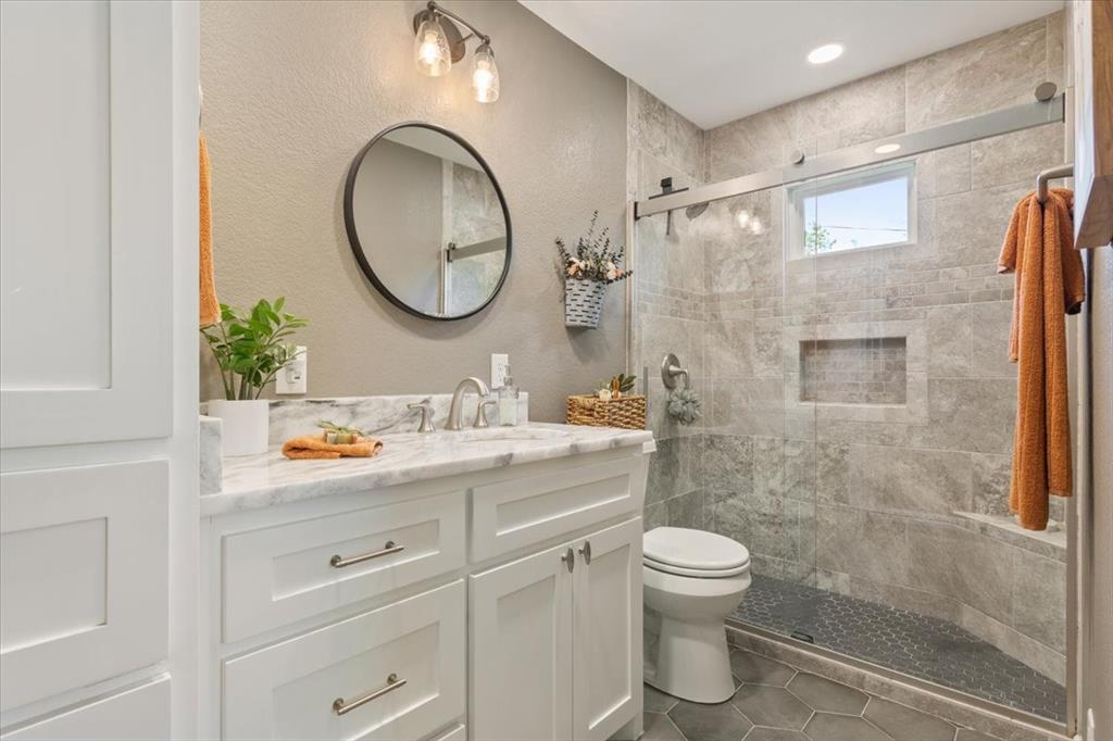 2209 North 52nd Street Waco, TX 76710 - Photo 21 of 34 a bathroom with a granite countertop sink a toilet and a mirror