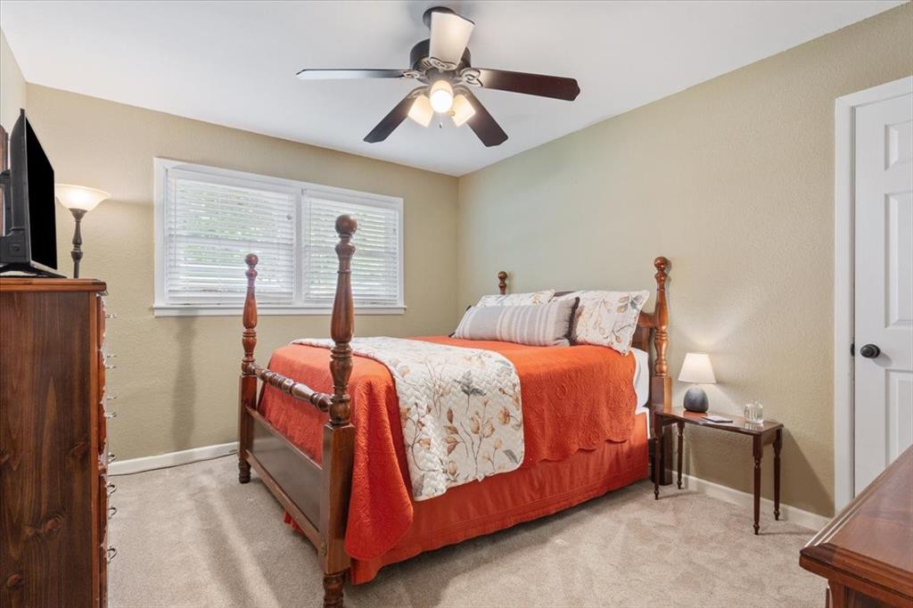 2209 North 52nd Street Waco, TX 76710 - Photo 22 of 34 a bedroom with a large bed and a chandelier