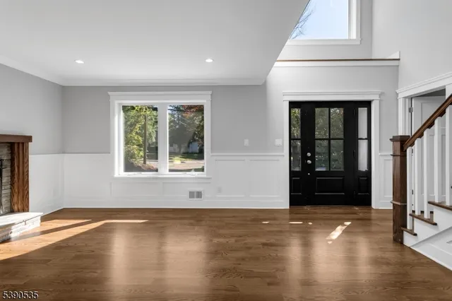 an empty room with wooden floor and a fireplace