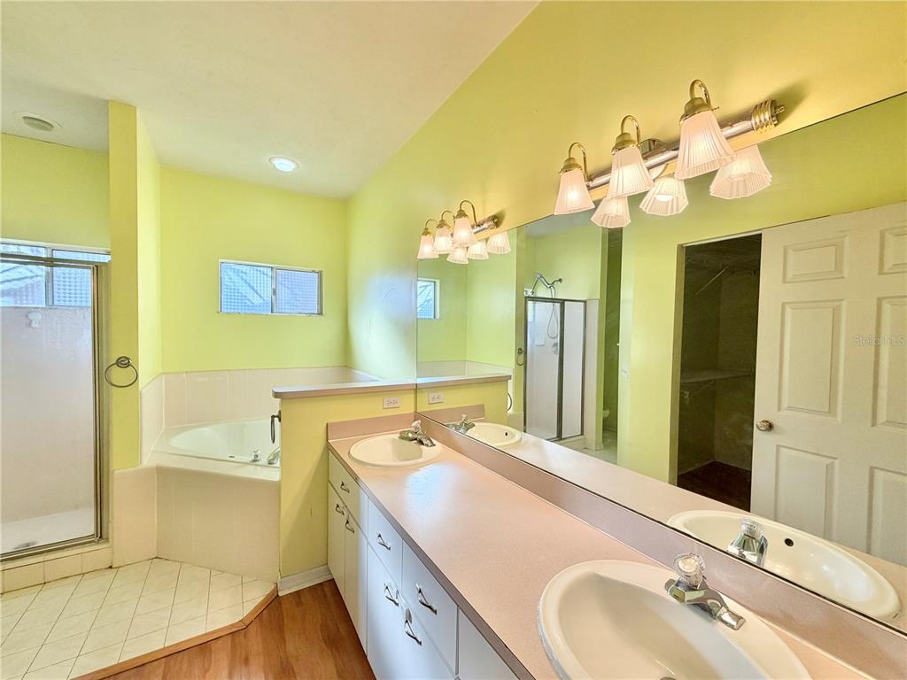 4423 Northwest 36th Street Gainesville, FL 32605 - Photo 26 of 43 a bathroom with a granite countertop sink a large mirror and a bathtub