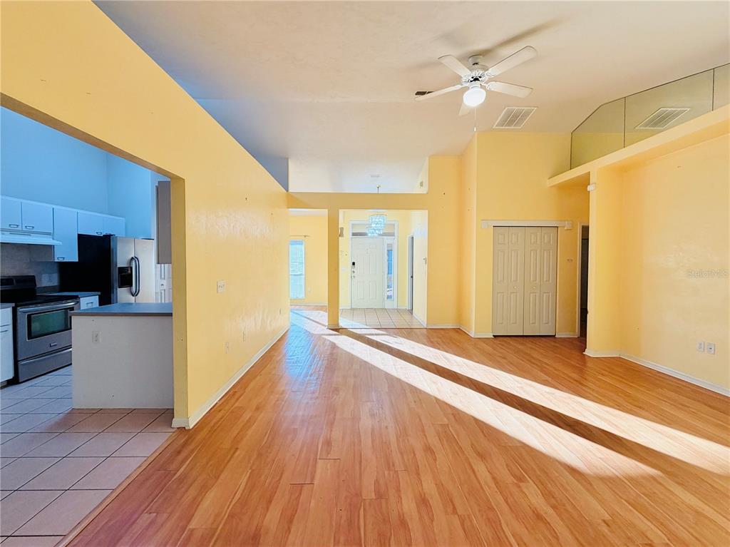 4423 Northwest 36th Street Gainesville, FL 32605 - Photo 10 of 43 a view of a big room with wooden floor a ceiling fan and windows