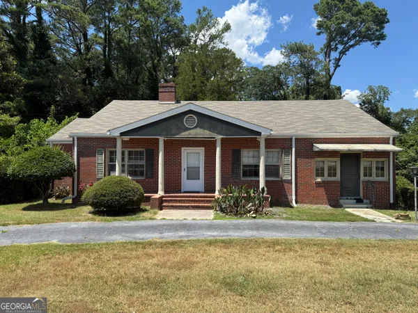 a front view of a house with a garden and plants