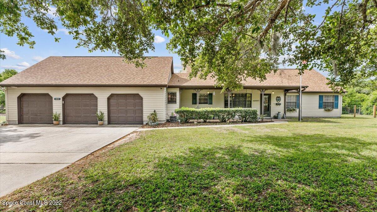 3655 Grant Line Road Mims, FL 32754 - Photo 1 of 47 a front view of a house with a garden