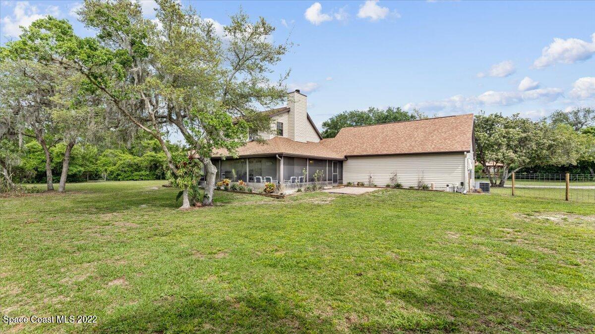 3655 Grant Line Road Mims, FL 32754 - Photo 34 of 47 a backyard of a house with table and chairs