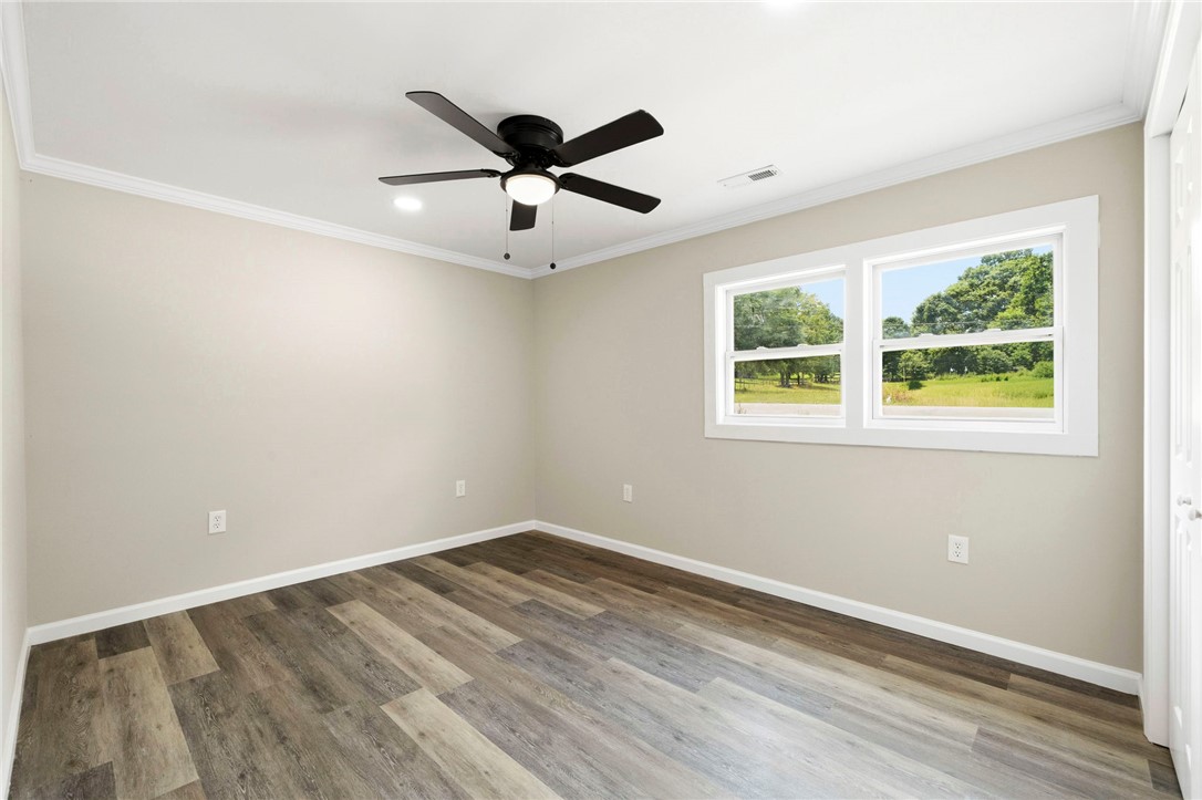418 Old River Road Pelzer, SC 29669 - Photo 18 of 29 Well-lit room with wood plank flooring and a view of the surrounding trees.
