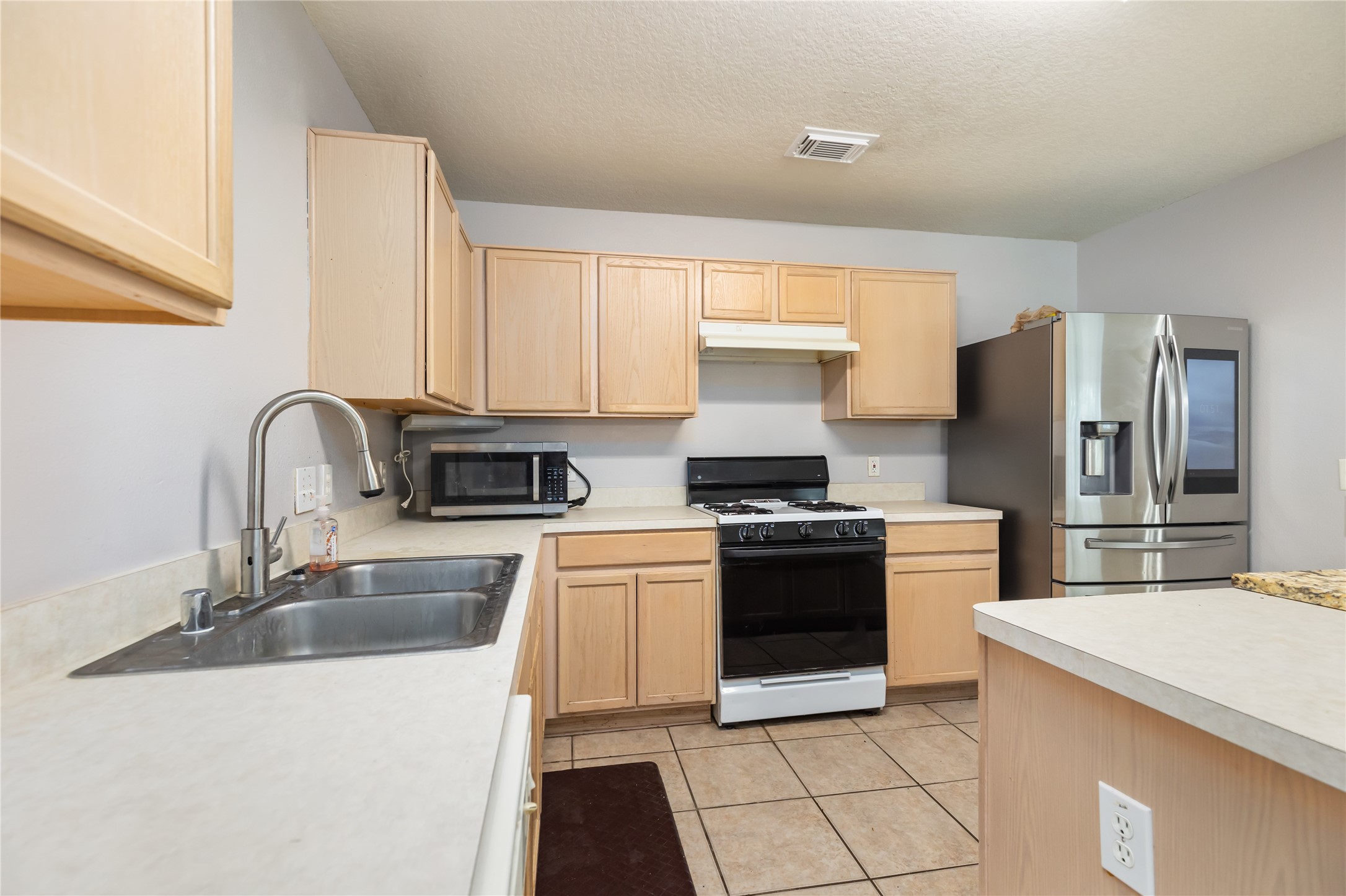17334 Turquoise Stream Drive Houston, TX 77095 - Photo 6 of 31 a kitchen with a sink stove and refrigerator