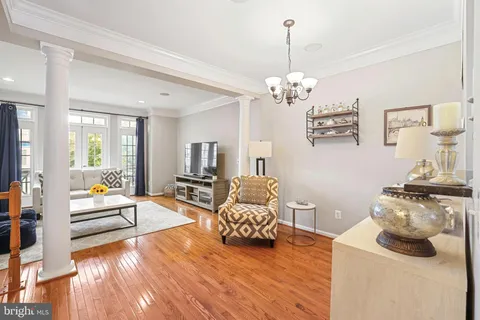 a living room with furniture a chandelier and a wooden floor