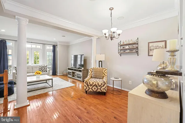 a living room with furniture a chandelier and a wooden floor