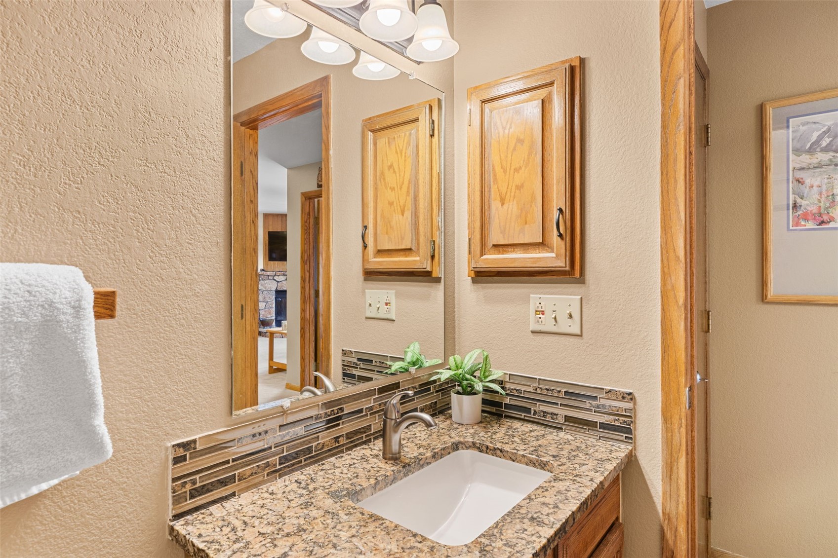 89410 Ryan Gulch Road, Unit DD301 Silverthorne, CO 80498 - Photo 18 of 28 a bathroom with a granite countertop sink and a mirror