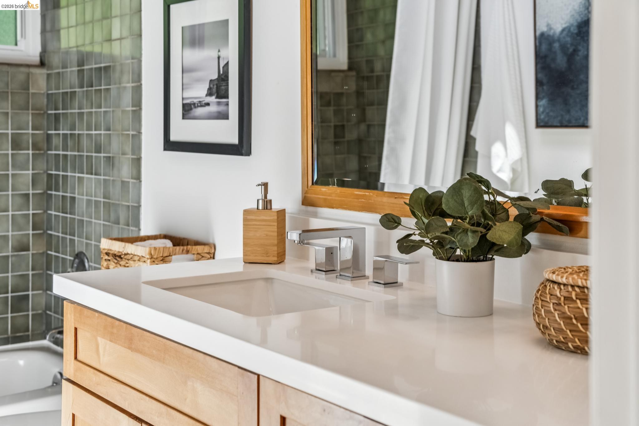 6645 Heather Ridge Way Oakland, CA 94611 - Photo 28 of 61 Bathroom vanity featuring a light wood-finish base cabinet, an integrated sink, and a white countertop