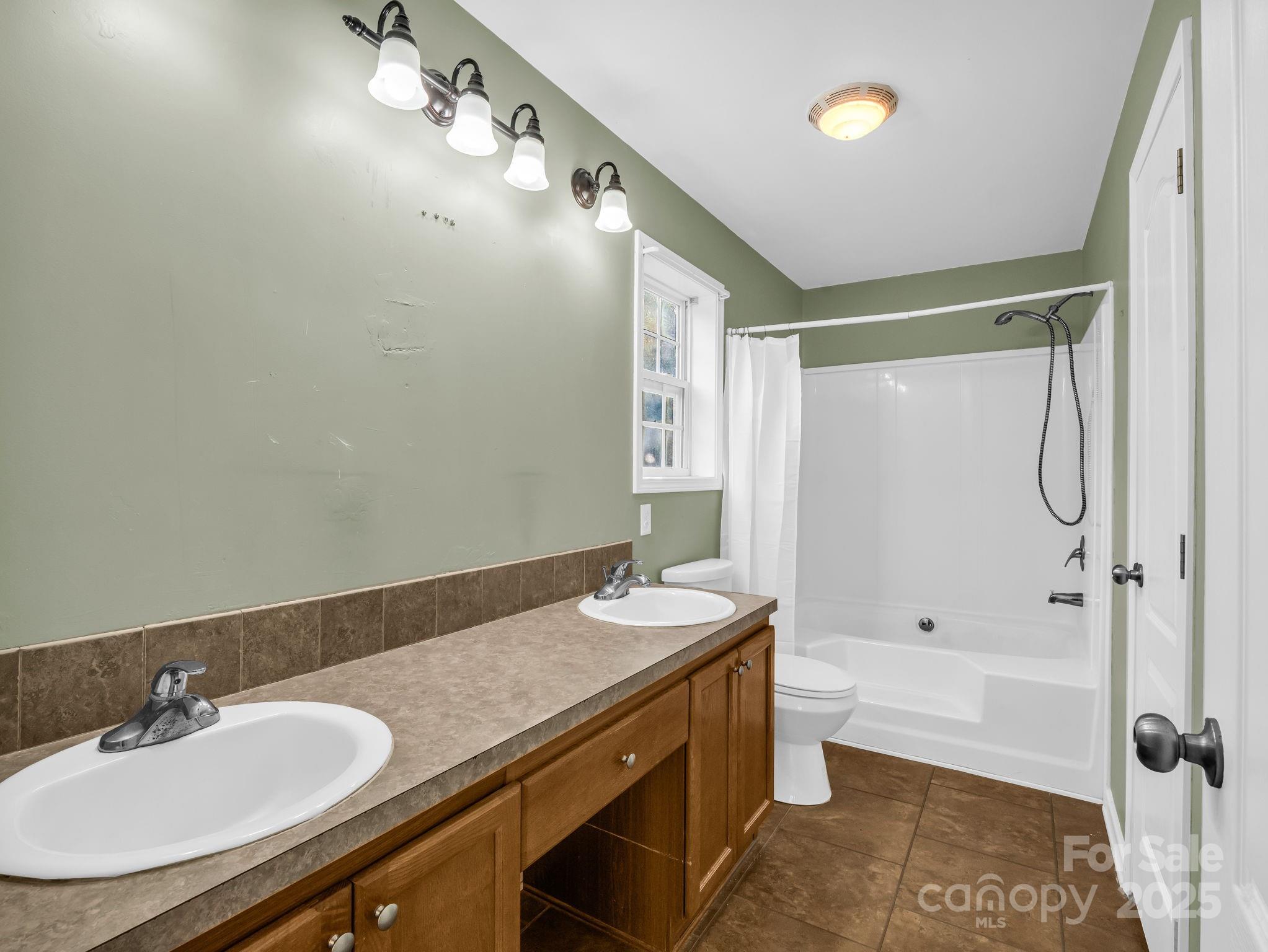 663 Landrum Road Columbus, NC 28722 - Photo 15 of 40 a bathroom with a granite countertop sink a mirror and a bathtub