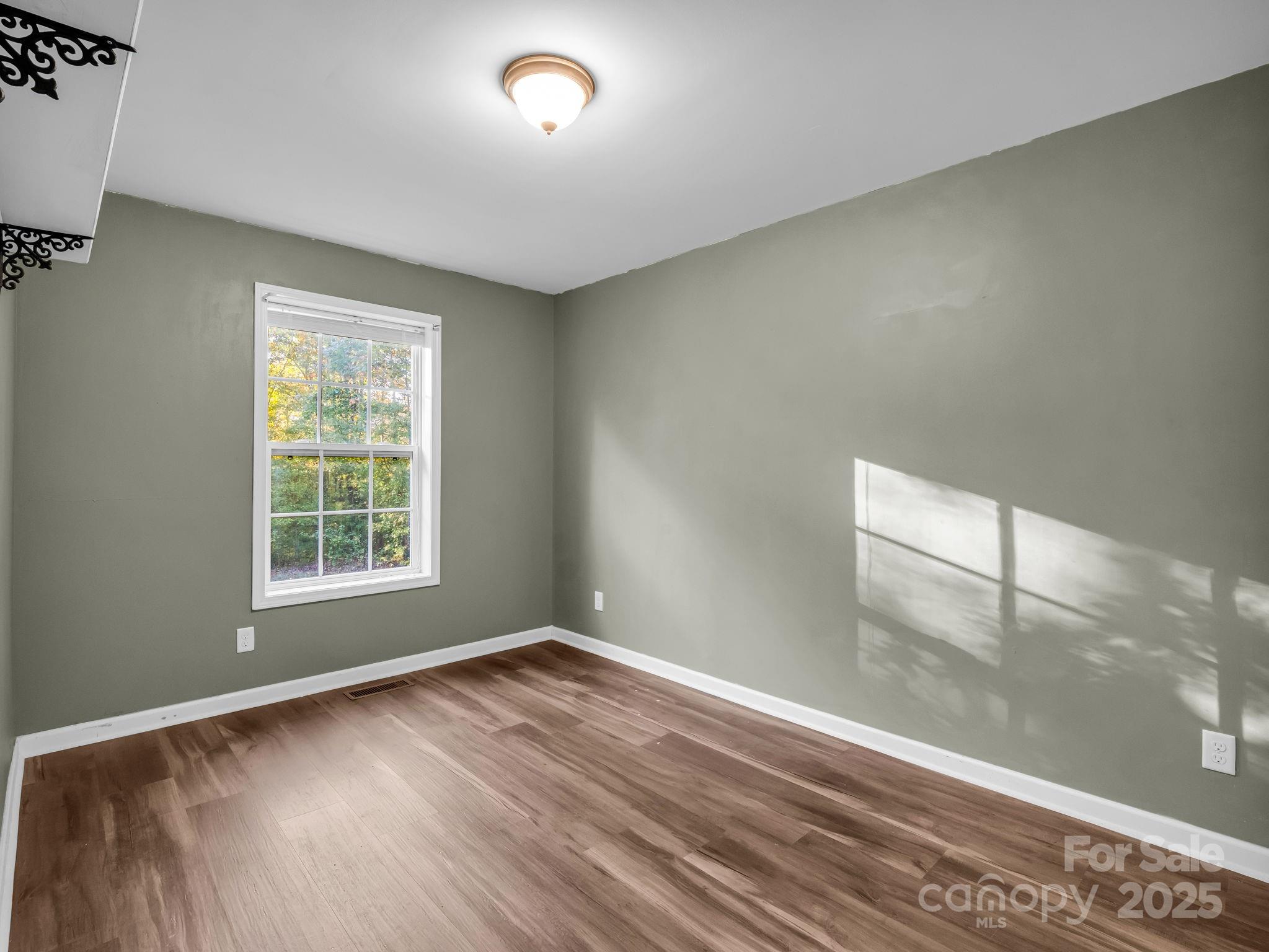 663 Landrum Road Columbus, NC 28722 - Photo 17 of 40 an empty room with wooden floor and windows
