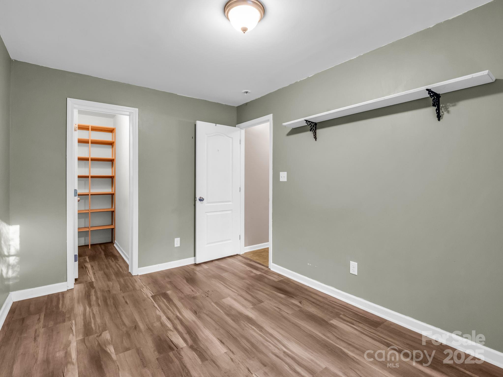 663 Landrum Road Columbus, NC 28722 - Photo 18 of 40 a view of room with walk in closet and wooden floor