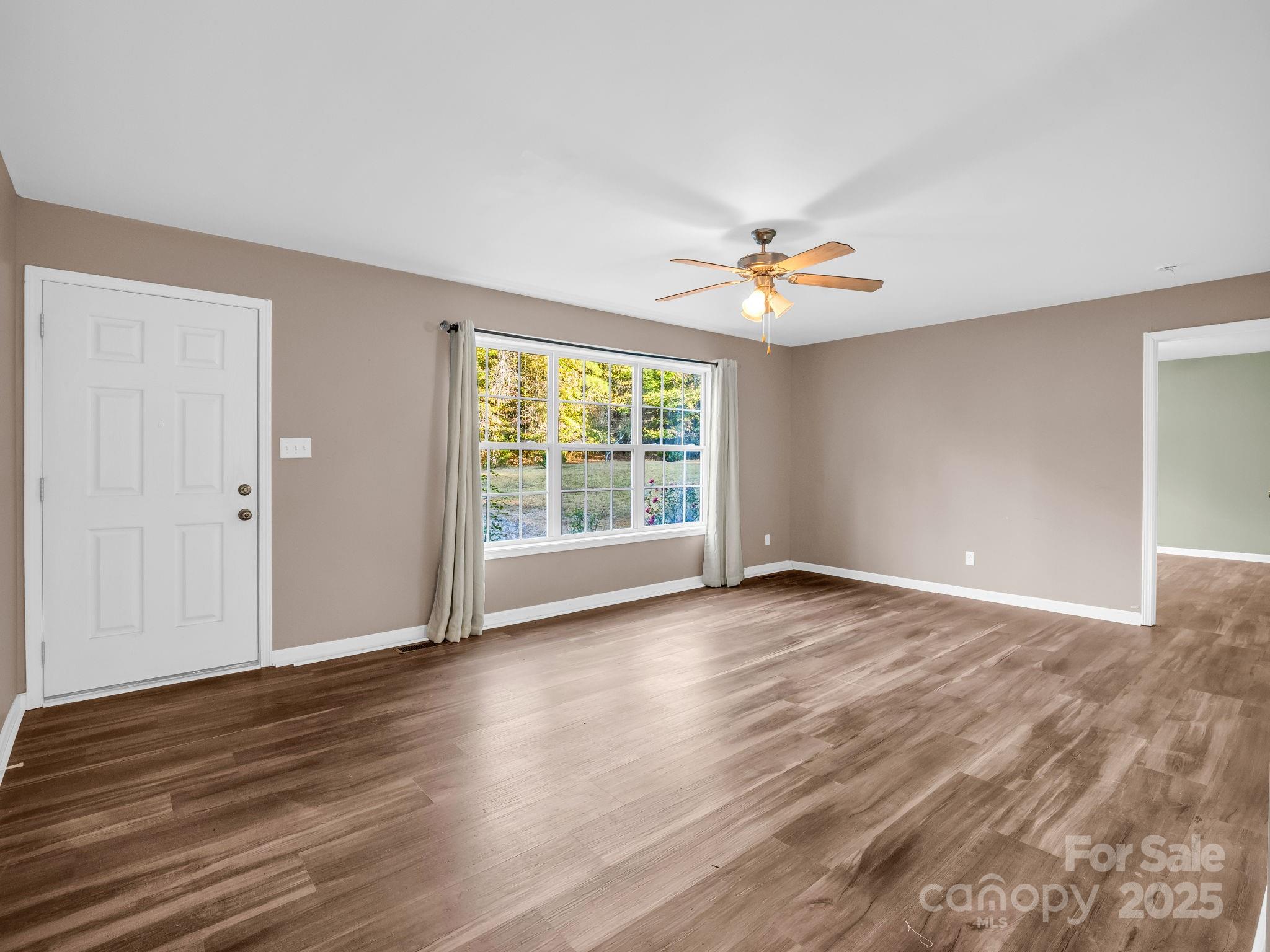 663 Landrum Road Columbus, NC 28722 - Photo 4 of 40 a view of an empty room with wooden floor and a window
