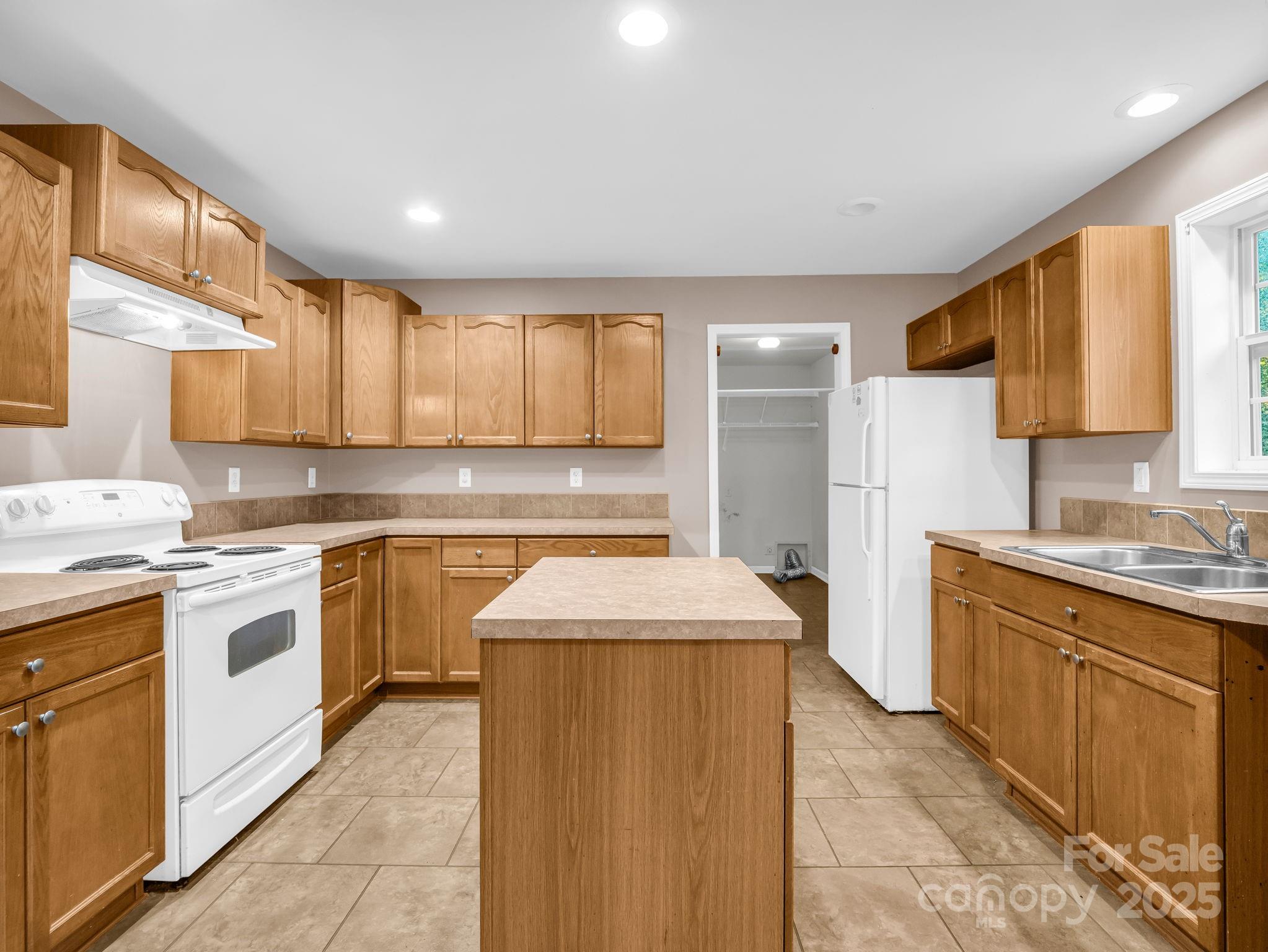 663 Landrum Road Columbus, NC 28722 - Photo 10 of 40 a kitchen with stainless steel appliances granite countertop a sink stove and refrigerator