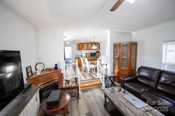 a living room with furniture a air conditioner and a flat screen tv