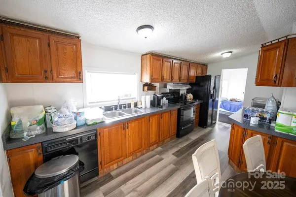 a kitchen with stainless steel appliances granite countertop a sink stove refrigerator and cabinets