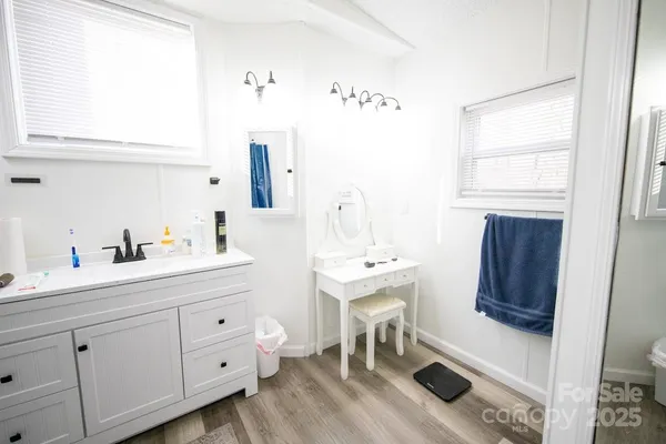 a en suite bathroom with a double vanity sink a mirror and a bathtub
