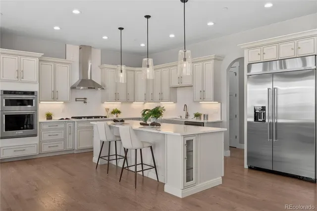 a kitchen with stainless steel appliances kitchen island a refrigerator and a stove top oven